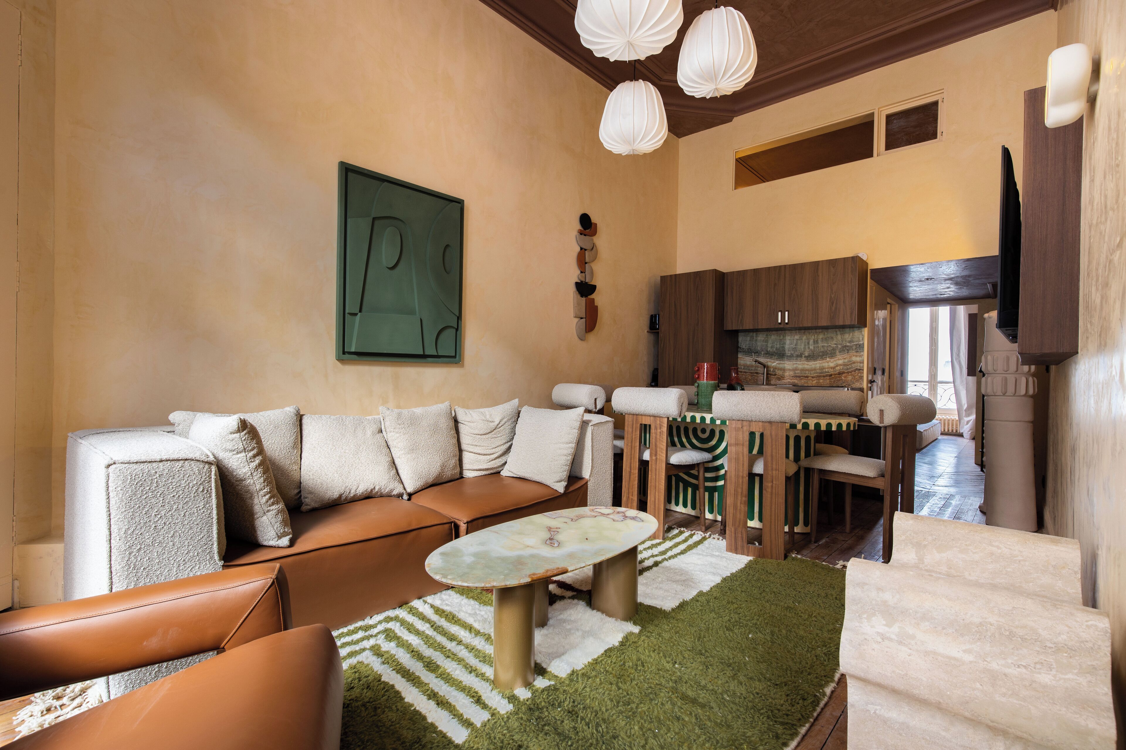 A modern living room with a sectional sofa, a coffee table, and a dining area with a wooden table and chairs.