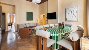 A dining area with a round table, cushioned chairs, and a green-striped tablecloth. - Hotel My Paris - Grands Boulevards (Paris)