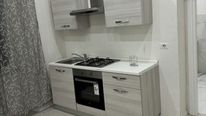 Une cuisine moderne dotée d’une cuisinière à gaz encastrée, d’un four et d’armoires en acier inoxydable.
