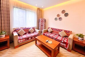 Ein Wohnzimmer mit zwei Sofas, einem Couchtisch und einer Wand mit Dekotellern.