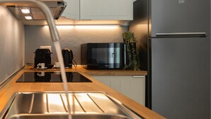 A modern kitchen with a stainless steel sink, a coffee maker, a microwave, and a refrigerator. - Flora Cozy Flat close to Metro (ROMA)