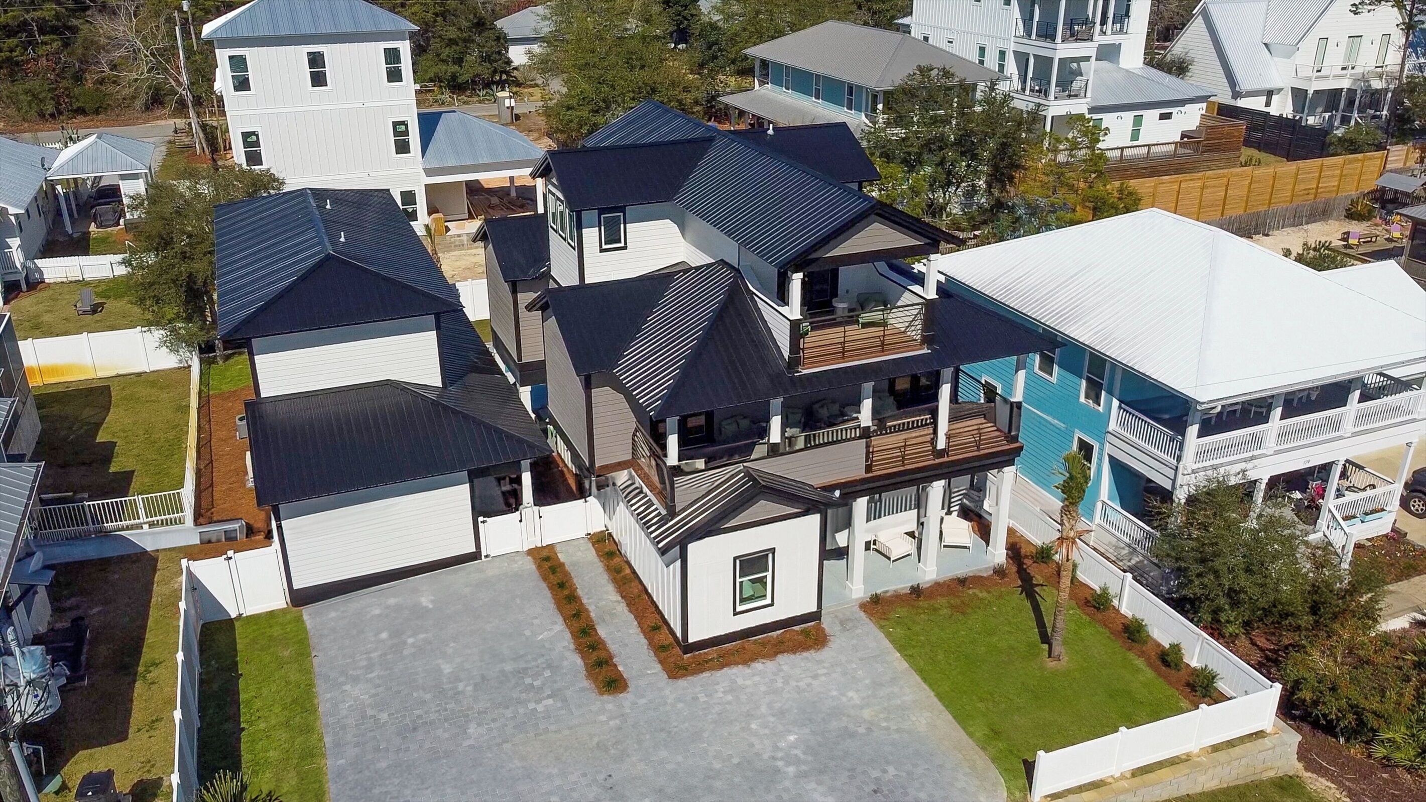 Et boligområde med flere huse, heriblandt et toetagehus med balkon og garage.