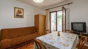 A living room with a sofa, a dining table with chairs, a television, and a wardrobe. - Pet friendly apartment in Porec with WiFi (Porec)