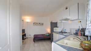 A compact kitchen with a bed, a microwave, a stove, and a sink. - Gorgeous home in OLETTA (OLETTA)