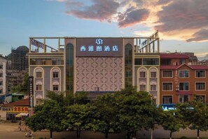 Un hôtel avec une grande enseigne, de nombreux étages et situé dans un environnement urbain.
