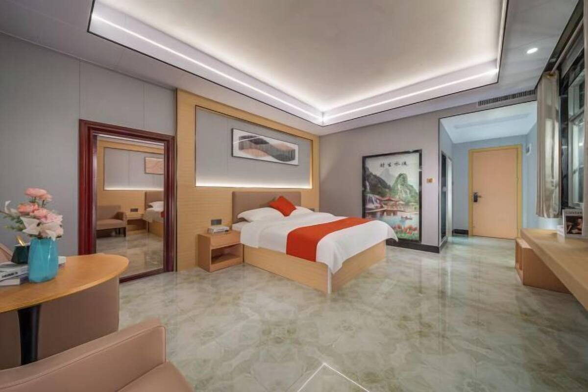 A modern hotel room with a bed, bedside table, and a mirror.