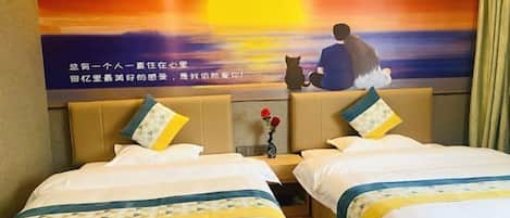 A hotel room with two beds, a sunset mural on the wall, and a vase with flowers on the nightstand.