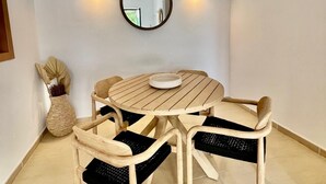 A round wooden dining table with four chairs, a wall-mounted mirror, and two wall sconces. - Son Carrió 6, Son Carrió 6 - Sa Perdiu 6 (Son Carrió)