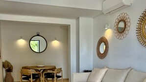 A modern living room with a beige sofa, a wooden dining table with chairs, and a round mirror on the wall. - Son Carrió 6, Son Carrió 6 - Sa Perdiu 6 (Son Carrió)