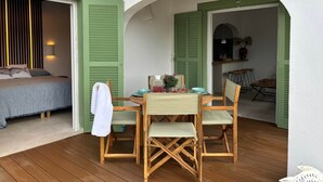A cozy room with a bed, a table with chairs, and a view of the kitchen through an archway. - Cales de Menorca 3, Cales de Menorca 3 - Cala Morell (Cala Blanca)