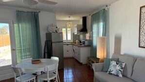 Un espace de vie compact comprenant un coin repas, une kitchenette et un canapé.
