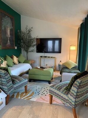 Relax in comfort with a large flat-screen TV, comfortable bed, and stylish seating area.
