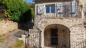 A stone building with a balcony and a wrought iron gate.