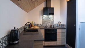 A modern kitchen with a built-in oven, a coffee machine, and a sink.