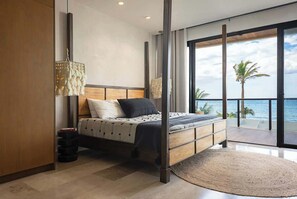 Une chambre moderne avec un grand lit, une vue sur l’océan et un balcon.