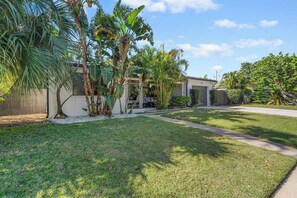 A residential property with a well-maintained lawn, palm trees, and a garage number 310.