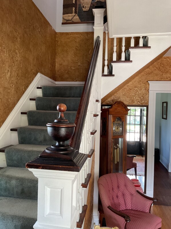 A staircase with a wooden handrail and a decorative urn at the top. - Charming 4 Bedroom Historic Home Centrally located in Northeastern Wisconsin (Chilton)