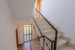 A staircase with a white railing and beige steps leading to a landing. - Casa Della Nonna (Pollutri)