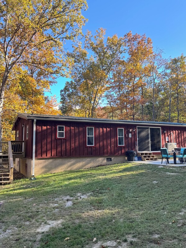 A single-story, red wooden cabin with a covered patio area. - 1987 “OAK SPRINGS”- Majestic-Tranquil-Serene… (Luray)