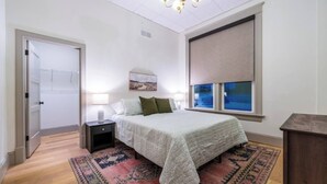 Un dormitorio con cama, mesita de noche y ventana con vistas.