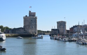 Stunning harbor views with a historic tower and boats in the foreground.