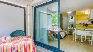 A room with a dining table, chairs, a bed, and a kitchen area. - Amazing apartment in La Rochelle with WiFi (La Rochelle)