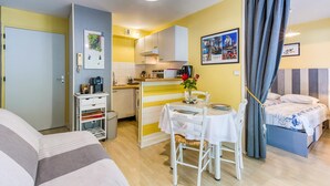 A compact, well-lit room with a kitchenette, a dining area, and a bed. - Amazing apartment in La Rochelle with WiFi (La Rochelle)