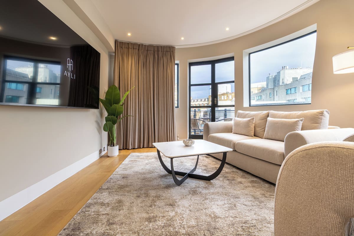 A modern living room with a sofa, a coffee table, and a potted plant.