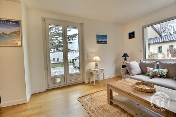 A living room with a sofa, coffee table, and a view through a glass door.