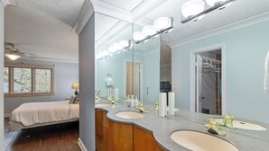 Een badkamer met twee wastafels, een grote spiegel en een inloopkast.