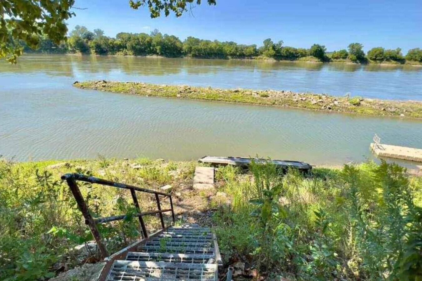 A river with a wooden staircase leading down to the water.