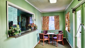A room with a window, a table with chairs, and a bulletin board with posted notices. - Hospitality Inn by Hotel O Selma US 80 (Selma)