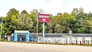 A blue building with a sign reading "Hospitality Inn" and a "No Parking" sign. - Hospitality Inn by Hotel O Selma US 80 (Selma)
