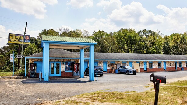 A motel with a blue exterior, a gas station attached, and a Coca-Cola sign. - Hospitality Inn by Hotel O Selma US 80 (Selma)