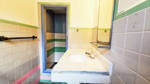 A bathroom with a white sink, a mirror, and a towel rack. - Hospitality Inn (Selma)