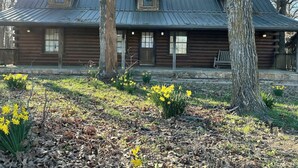 A log cabin with a metal roof, surrounded by trees and yellow flowers. - Rustic but elegant 4-bedroom farmhouse in Canton with WiFi and AC (Canton)