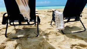Two beach chairs on a sandy beach with a clear blue sky and ocean in the background. - The Cove Hotel St.Croix  (Christiansted)