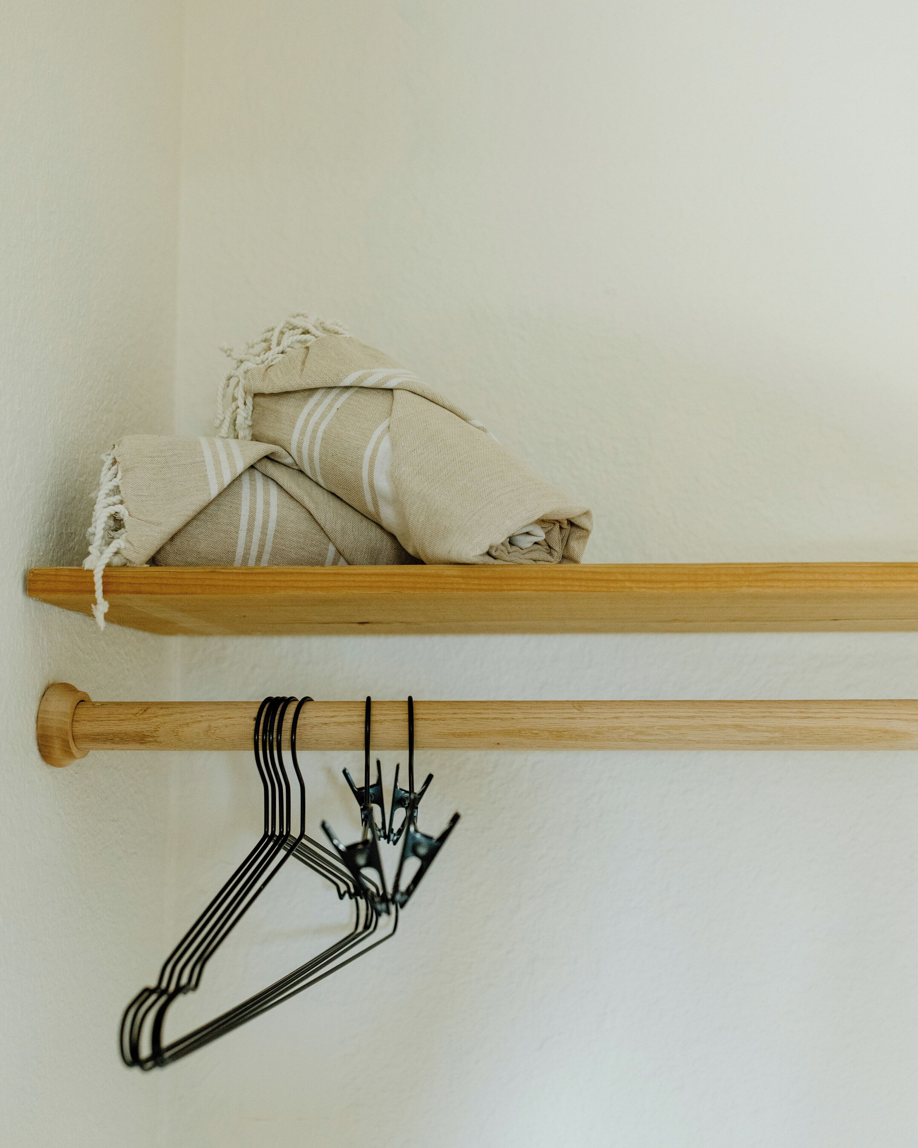 Een houten plank met opgevouwen handdoeken en een metalen kapstok.