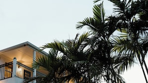 A multi-story building with balconies and arches, surrounded by palm trees. - The Cove Hotel St.Croix  (Christiansted)