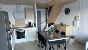 A modern kitchen with a dining area, wooden ceiling, and a clock on the wall. - MINI-VILLA - LEA TARCO - SEA VIEW - AIR CONDITIONING (TARCO CONCA)