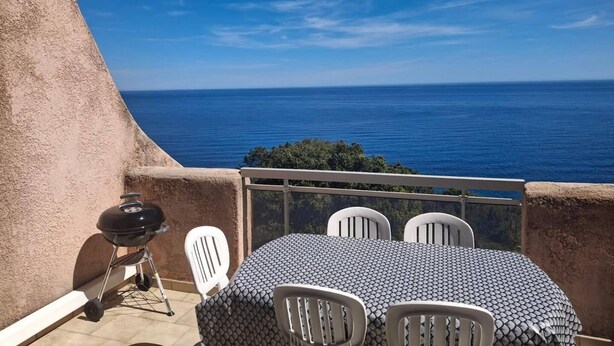A balcony with a table and chairs, overlooking a body of water. - MINI-VILLA - LEA TARCO - SEA VIEW - AIR CONDITIONING (TARCO CONCA)