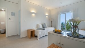 Un dormitorio moderno con cama, mesita de noche y vistas al exterior.