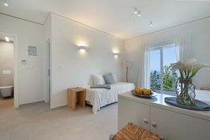 Un dormitorio moderno con cama, mesita de noche y vistas al exterior.