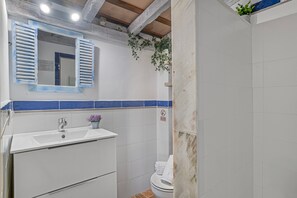 A bathroom with a sink, mirror, and toilet. - Holiday Home 'Laura' with Shared Pool, Wi-Fi and Air Conditioning (Conil de la Frontera)