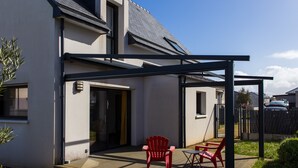 Una casa moderna con un porche cubierto, una puerta y una ventana.