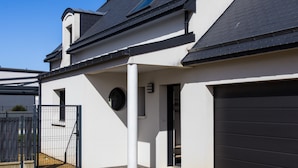 A modern house with a garage, a covered porch, and a fenced yard.