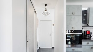 A modern kitchen with a built-in oven, a coffee maker, and a sleek countertop.