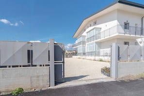 A gated entrance to a modern building with a balcony on the second floor. - Room 'Leverblu  5' with Shared Terrace, Wi-Fi and Air Conditioning (Avola)