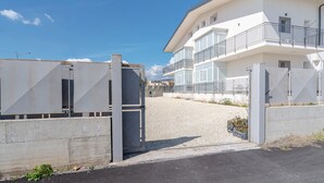 A gated entrance to a modern building with a balcony on the second floor. - Room 'Leverblu  6' with Shared Terrace, Wi-Fi and Air Conditioning (Avola)