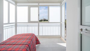 A room with a bed, large windows, and a view of the outside. - Room 'Leverblu  6' with Shared Terrace, Wi-Fi and Air Conditioning (Avola)
